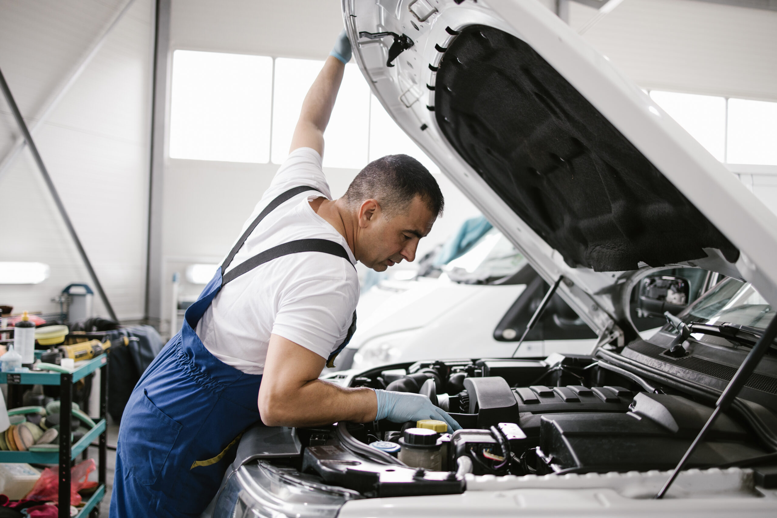 Car service mechanic worker standing in front of car engine open