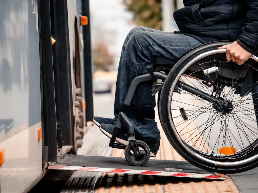 A person in a wheelchair uses a ramp to board a bus