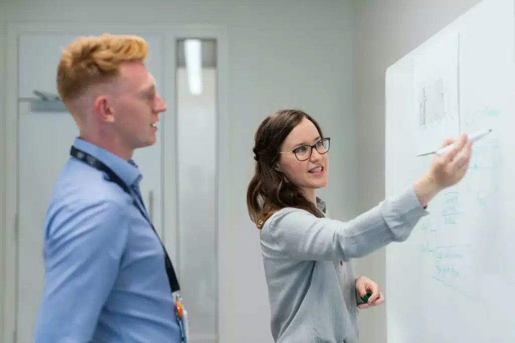 Two engineers writing on a whiteboard