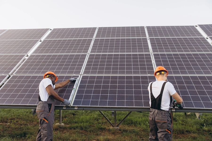 An image showing two people working on a solar panel