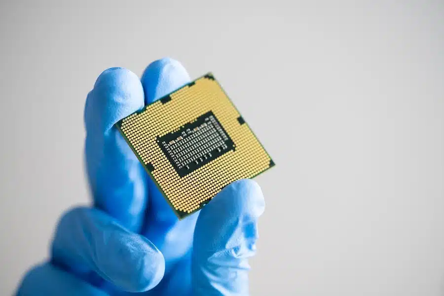 An image of a CPU being held by a gloved hand