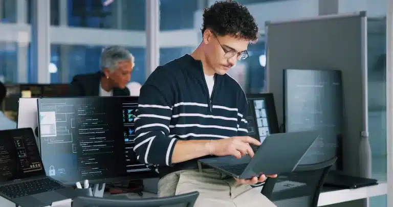 A person working on a laptop in a cybersecurity business. This image accompanies GrantTree's blog on Contracts for Innovation: Cyber scale in critical sectors