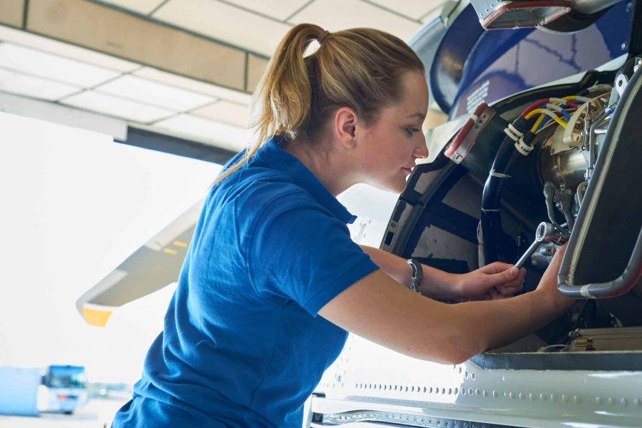 Female Aero Engineer Working On Helicopter In Hangar