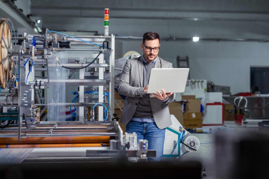 Manager industrial engineer using laptop check and control automation.