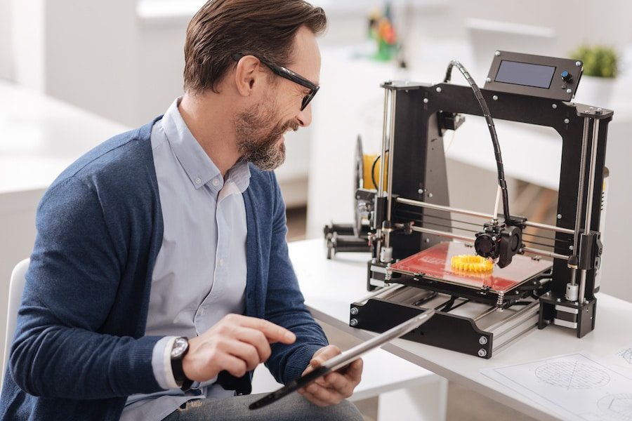 Handsome positive man designing a new object