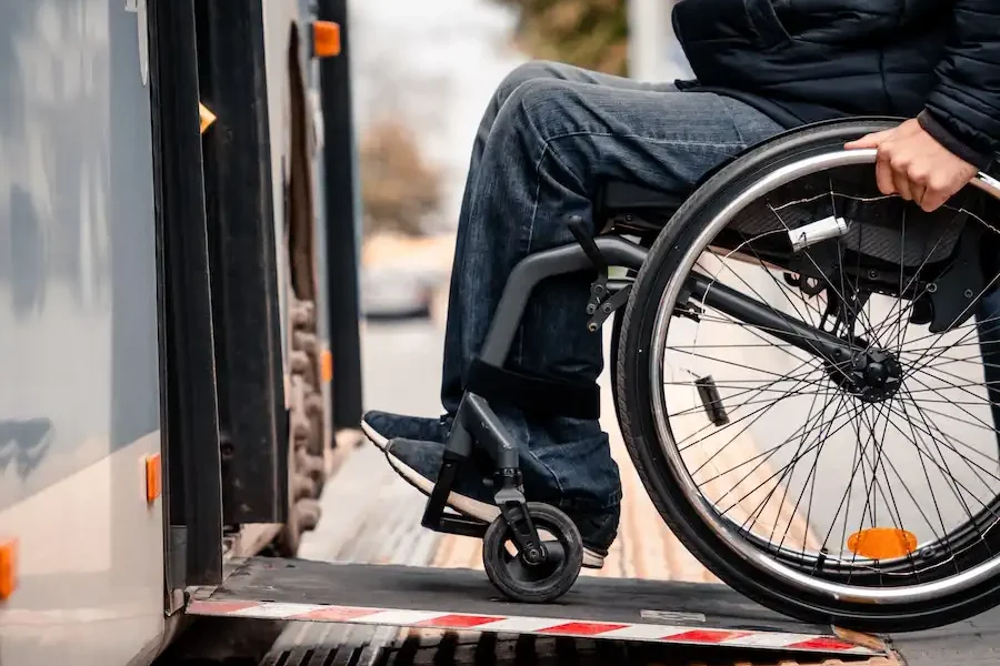 A person in a wheelchair uses a ramp to board a bus