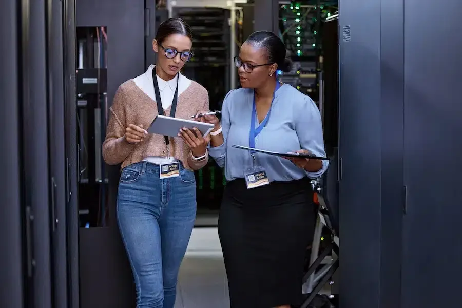 Women in Innovation - two women, flanked by servers, looking at tablets